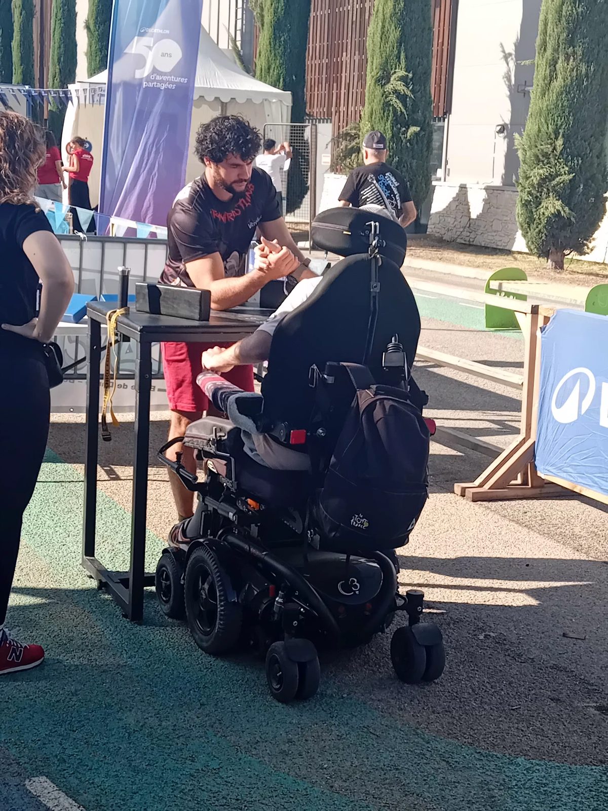 Rencontre de bras de fer sportif entre un athlète valide et un athlète en fauteuil